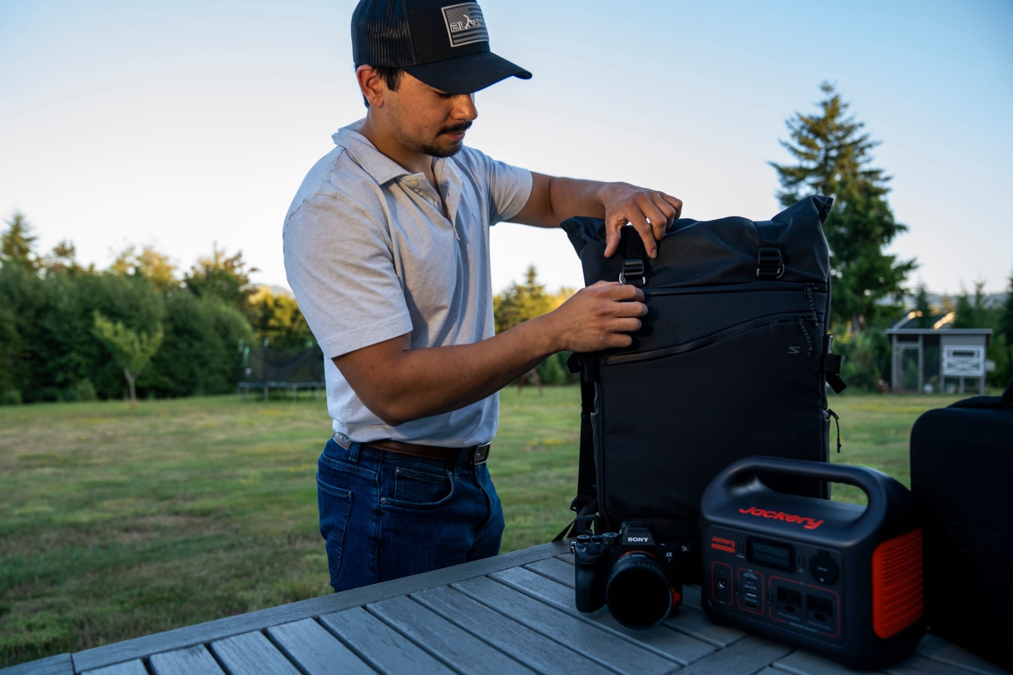 DJ Riley packing his camera bag before a shoot, with a Sony camera and portable power station on the table